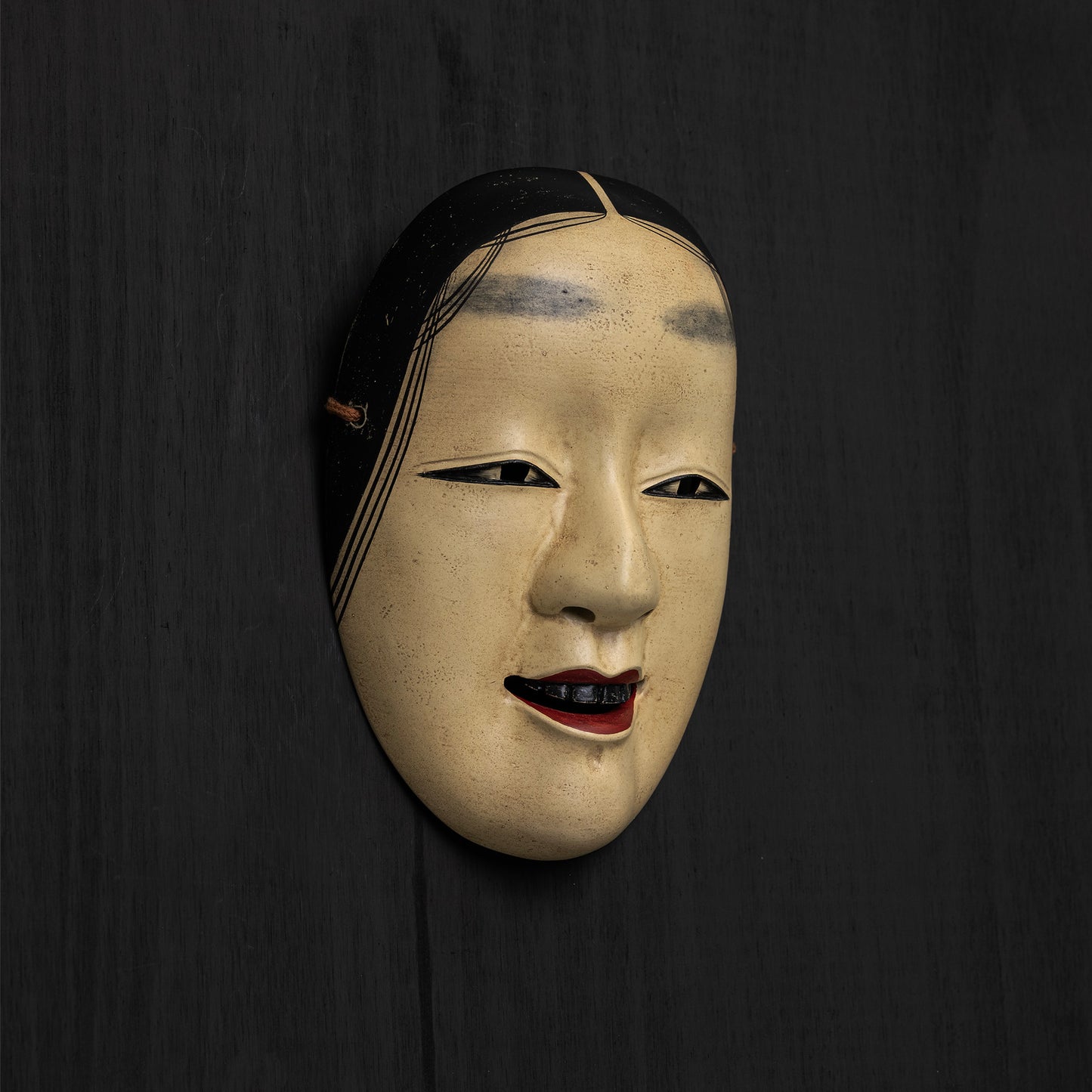 Koomote Mask mounted on black wall